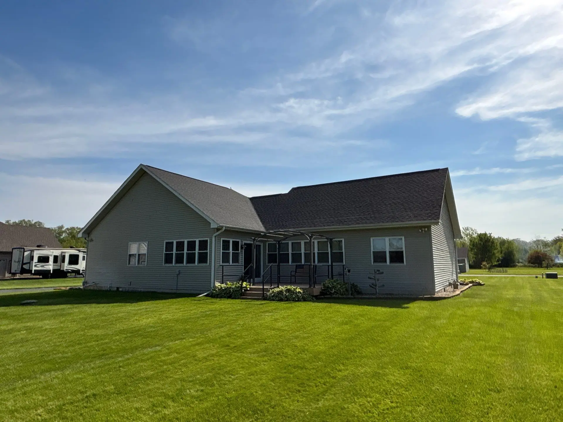 Back view of a home featuring a newly installed roof replacement completed by Quad County Roofing.