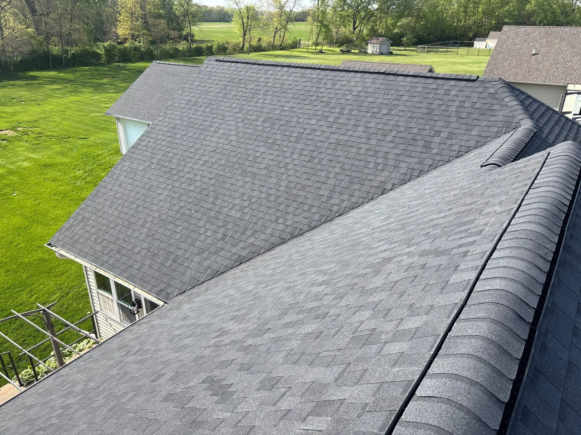 Close-up aerial view of a professionally installed shingle roofing system on a residential home.