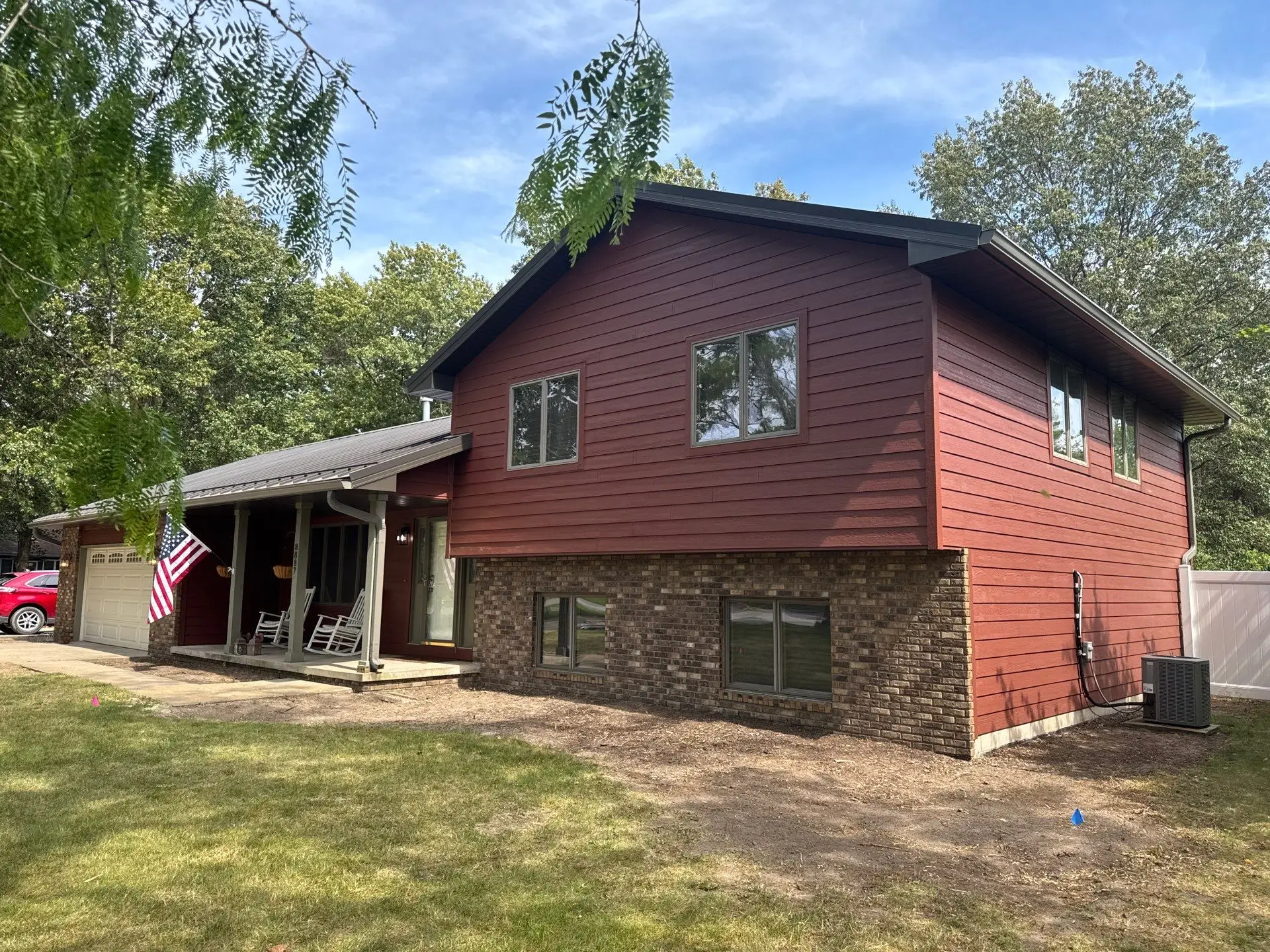 Completed siding replacement project featuring durable red siding and updated exterior finishes.